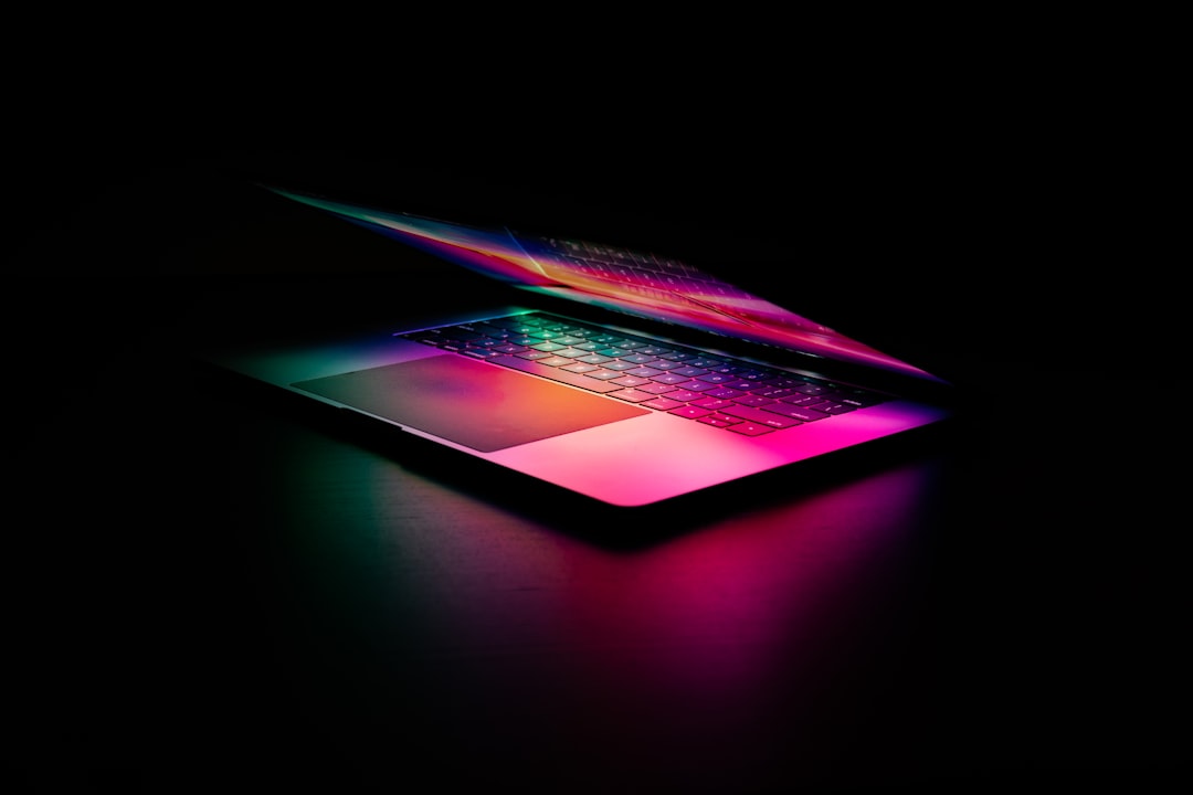 A glowing laptop with colorful lighting on a dark background